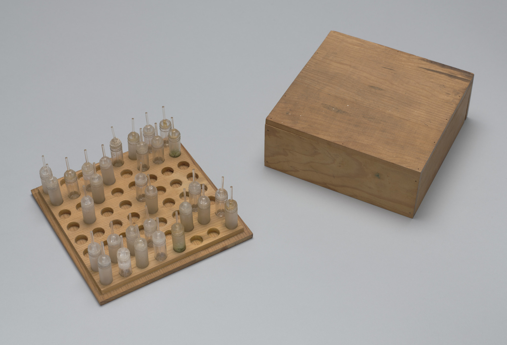 Praca TAKAKO SAITO „SMELL CHESS”, drewniana szachownica na której zamiast pionków  ustawiono fiolki z zapachami